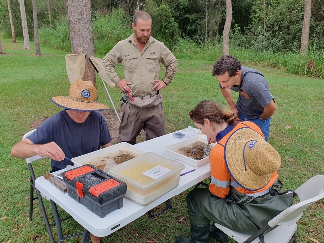 Scientists and stakeholders around a table checking findings in the water samples