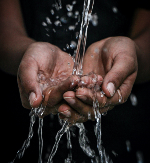 two hands catching water from a tap
